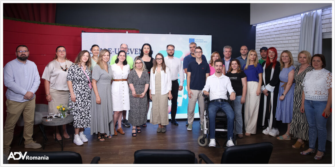 Grup de persoane la un eveniment corporativ, stând în fața unui panou de prezentare într-o cameră cu pereți roșii.
